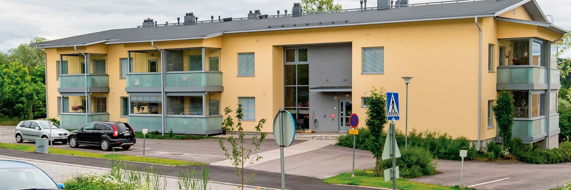 Palvelutalo Sofie, kaksikerroksinen rakennus, jossa on parvekkeita ja pysäköintialue rakennuksen edessä.